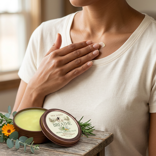 Adult gently applying a tiny amount of Breathe salve below the collarbone, with the updated tin nearby